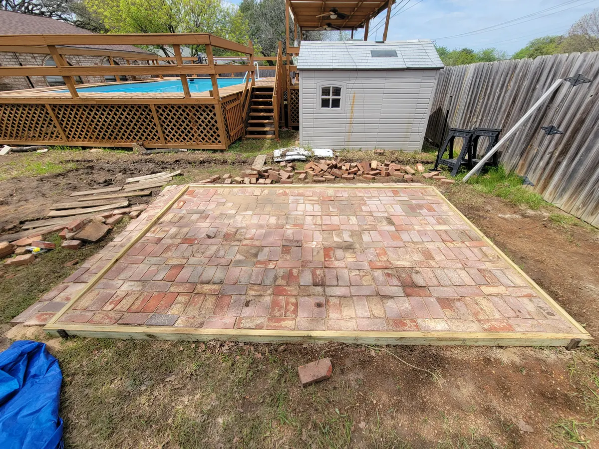 Brick pad installation in a backyard work area